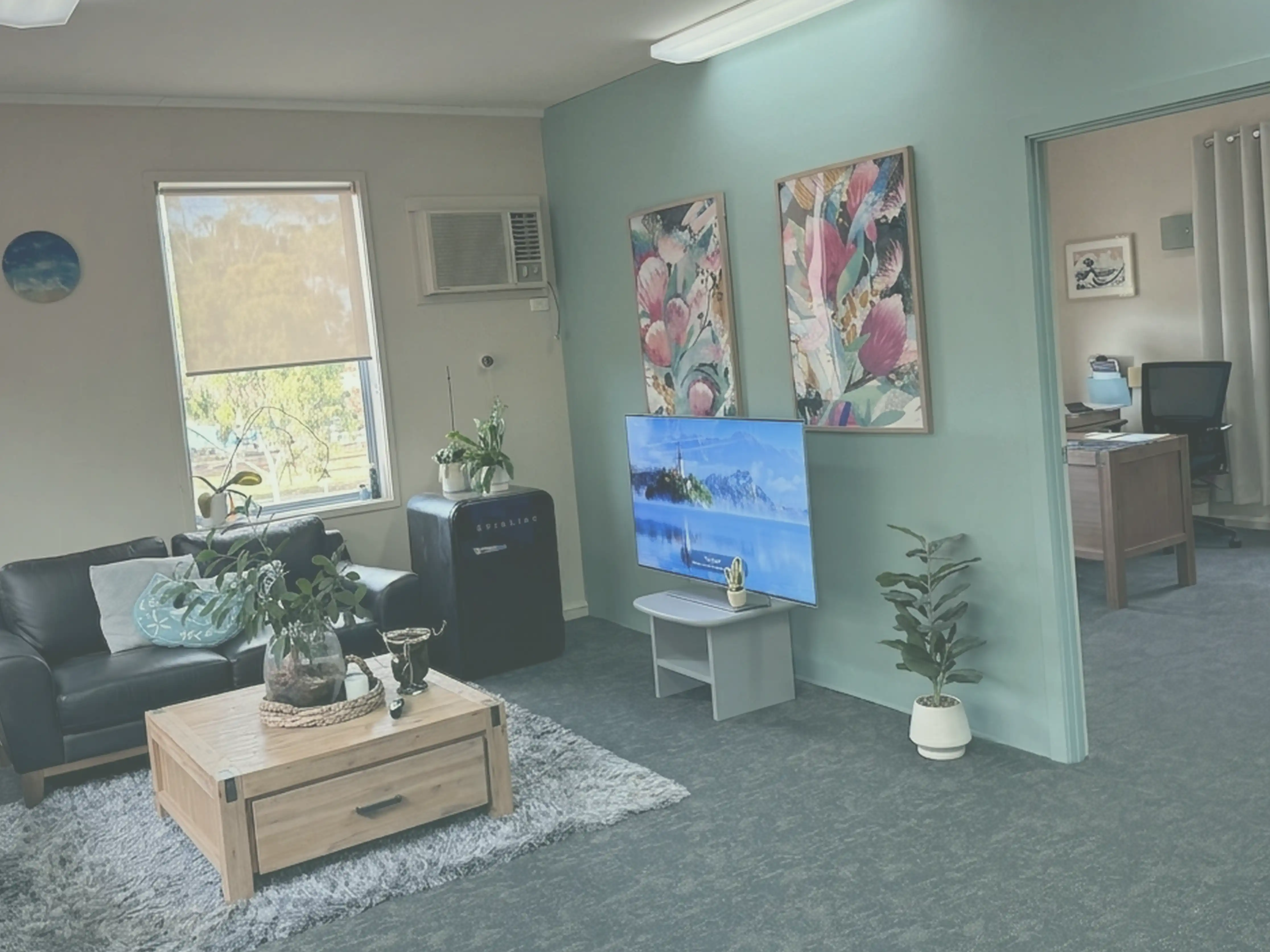 Deb Walker Accounting office — welcoming reception with leather lounge, teal feature wall, and natural light