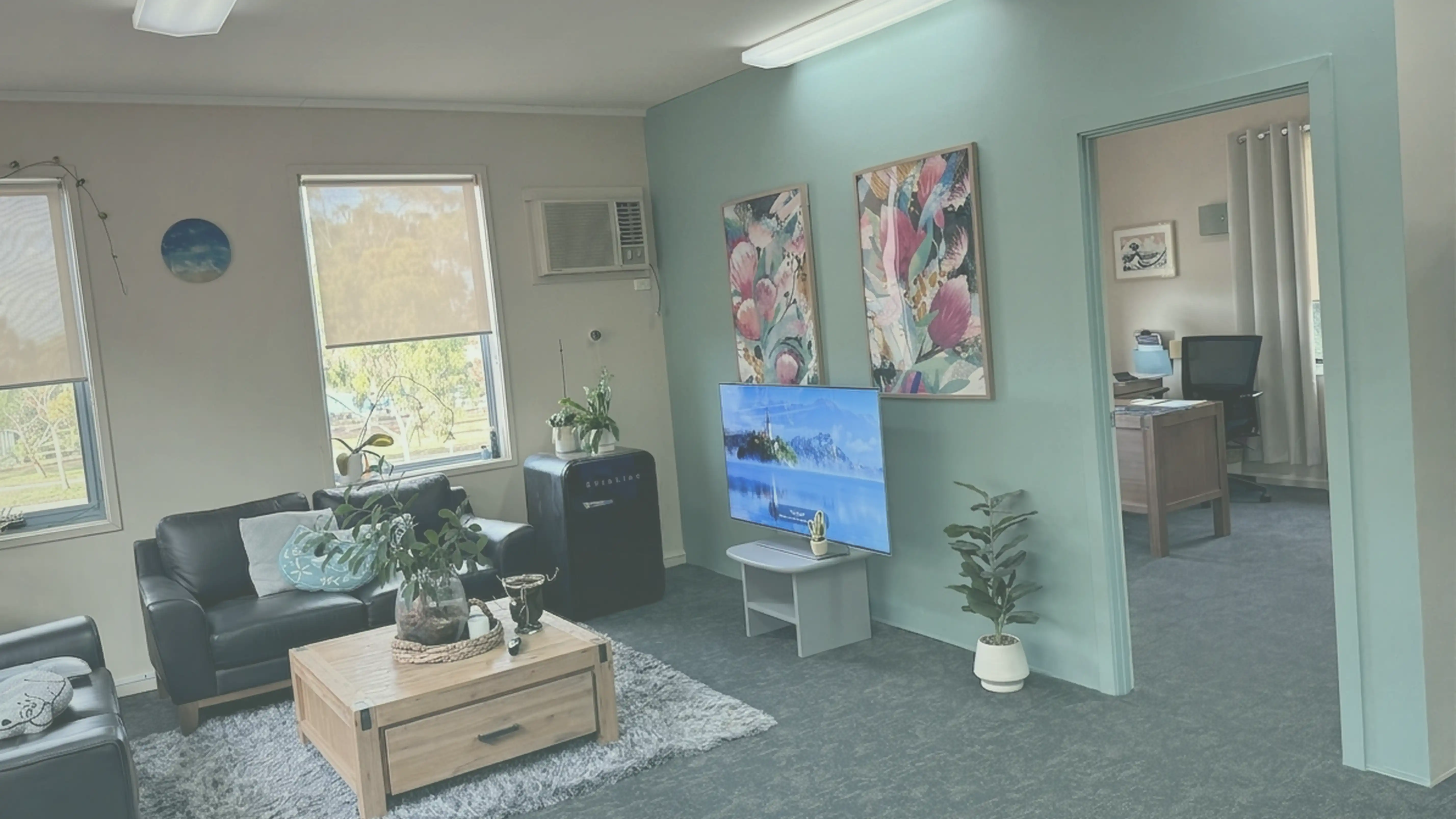 Deb Walker Accounting reception — inviting lounge with teal feature wall, floral artwork, and natural light